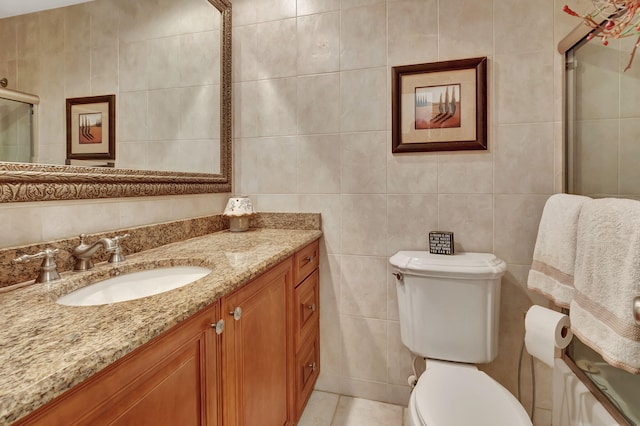 bathroom with vanity, toilet, tile walls, and an enclosed shower