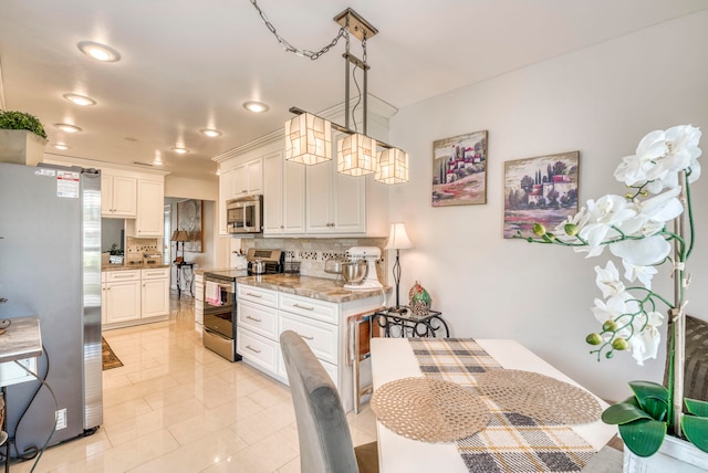 kitchen with light stone counters, hanging light fixtures, backsplash, white cabinetry, and appliances with stainless steel finishes