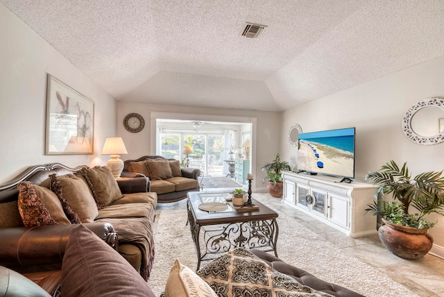 tiled living room featuring a textured ceiling and lofted ceiling