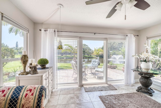 entryway featuring a water view, a textured ceiling, and ceiling fan