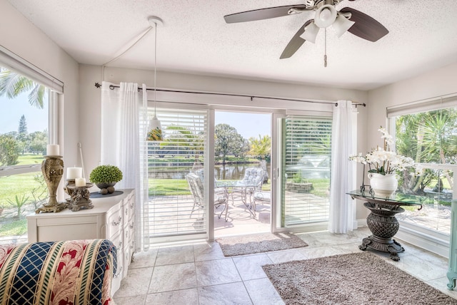 doorway to outside featuring ceiling fan, plenty of natural light, and a textured ceiling