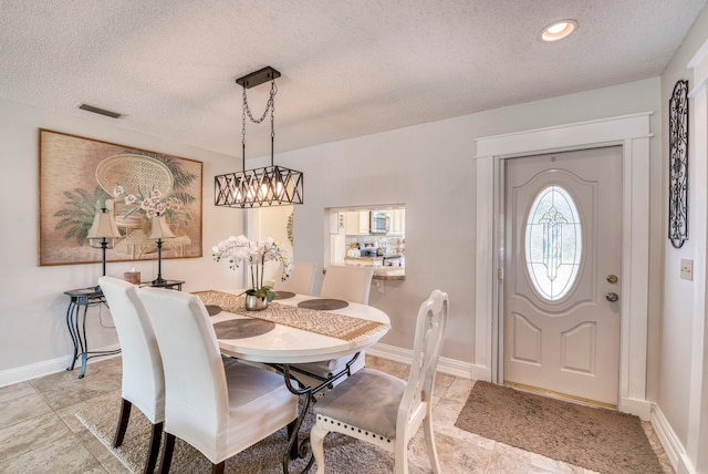 dining space with a textured ceiling and light tile patterned floors