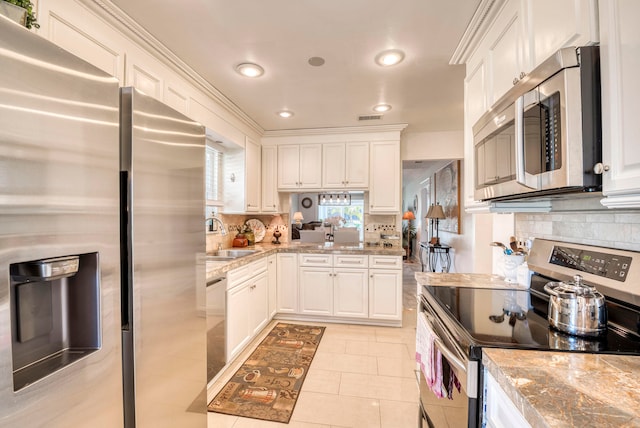 kitchen featuring white cabinetry, sink, appliances with stainless steel finishes, light tile patterned floors, and backsplash