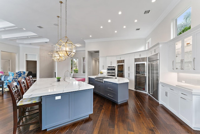 kitchen featuring white cabinets, a spacious island, and hanging light fixtures