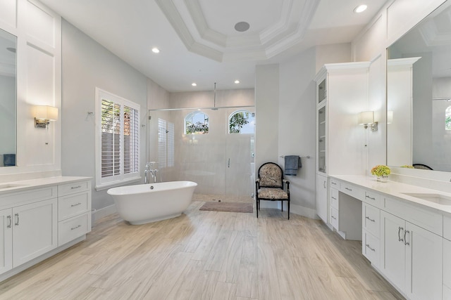 bathroom featuring ornamental molding, vanity, a raised ceiling, separate shower and tub, and hardwood / wood-style flooring