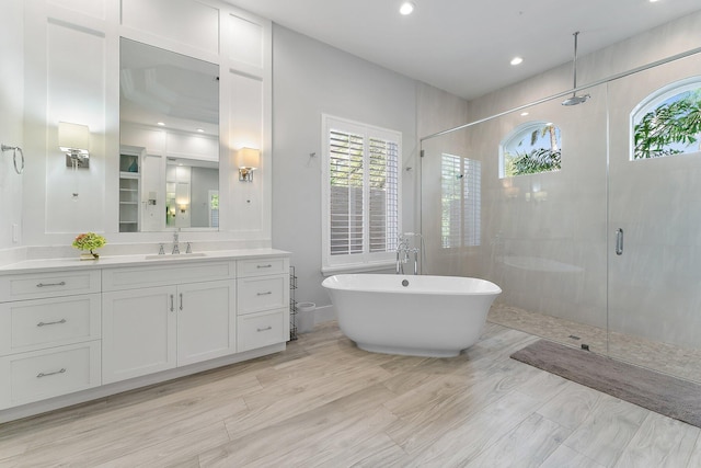 bathroom featuring vanity and independent shower and bath