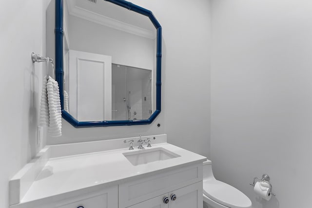 bathroom featuring toilet, vanity, and ornamental molding