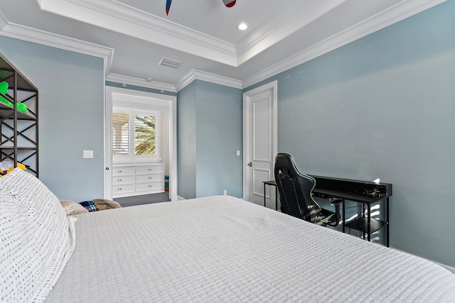 bedroom featuring ceiling fan, ornamental molding, and a tray ceiling