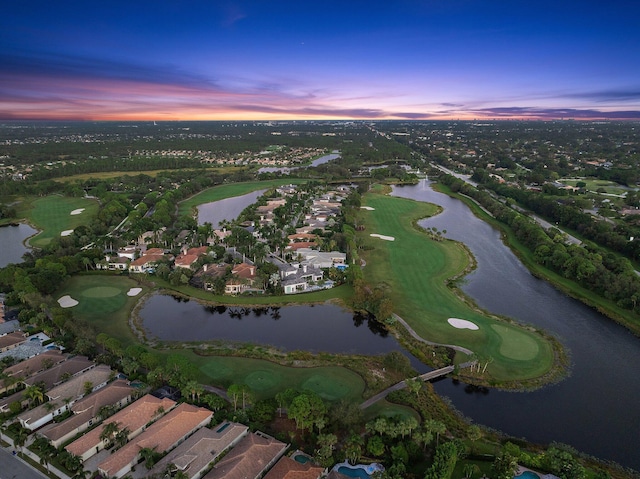 aerial view at dusk featuring a water view