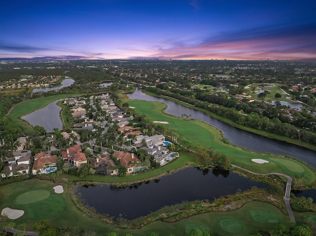 aerial view at dusk featuring a water view