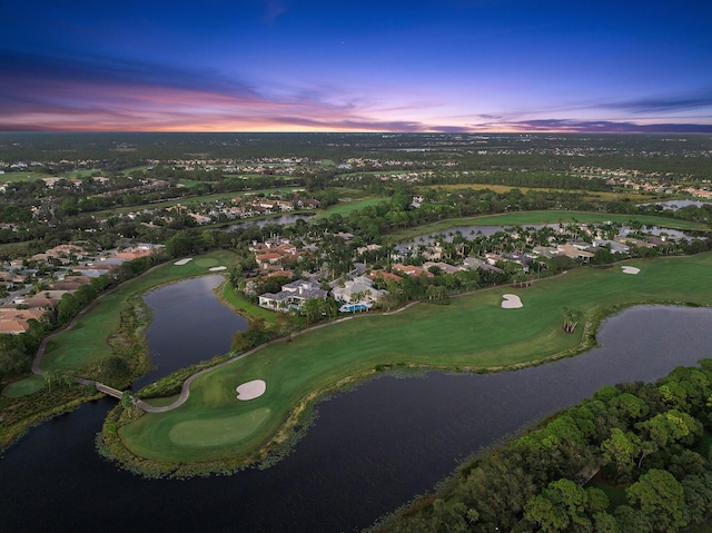 aerial view at dusk featuring a water view