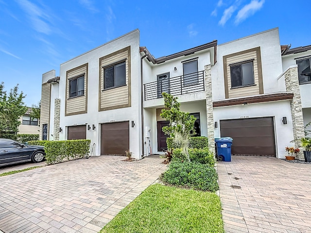 view of front of property featuring a garage and a balcony