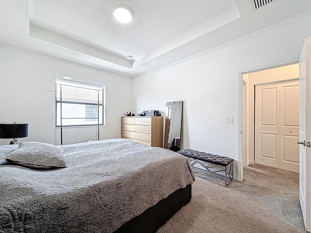 carpeted bedroom with a tray ceiling