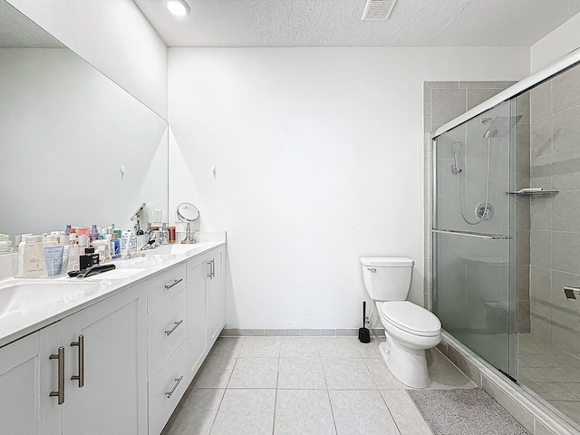 bathroom featuring toilet, tile patterned floors, a textured ceiling, vanity, and a shower with shower door