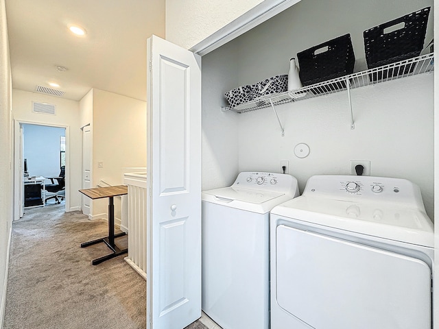 laundry room with light colored carpet and washer and dryer