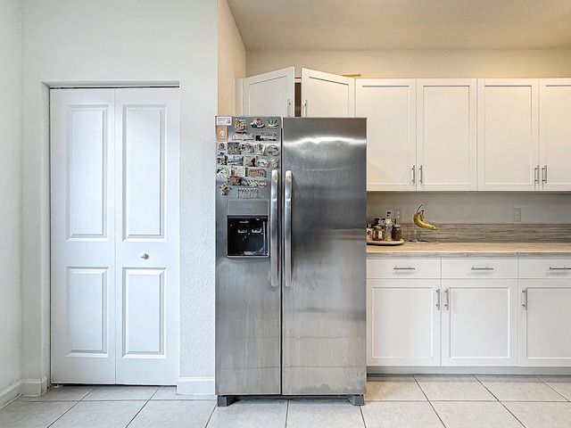 kitchen with white cabinetry, stainless steel fridge with ice dispenser, and light tile patterned floors