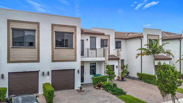 view of front of property featuring a garage and a balcony