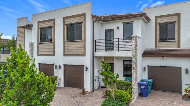 view of front facade featuring a garage and a balcony