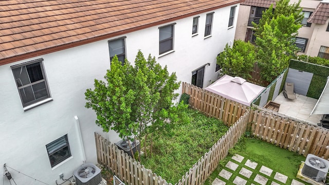 view of side of property with central AC and a patio