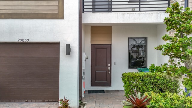 doorway to property featuring a garage and a balcony