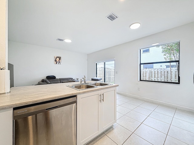 kitchen with dishwasher, plenty of natural light, white cabinetry, and sink