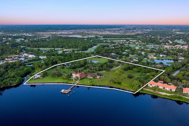 aerial view at dusk featuring a water view