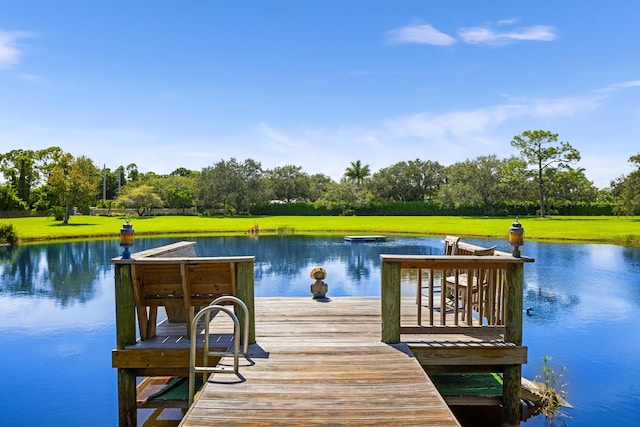 dock area with a yard and a water view