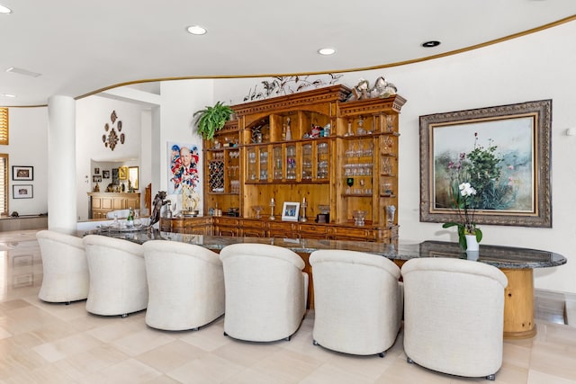 bar featuring crown molding and light tile patterned floors