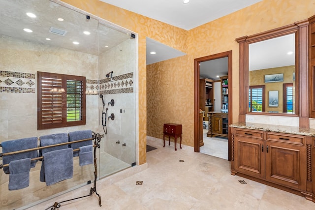 bathroom featuring tiled shower and vanity