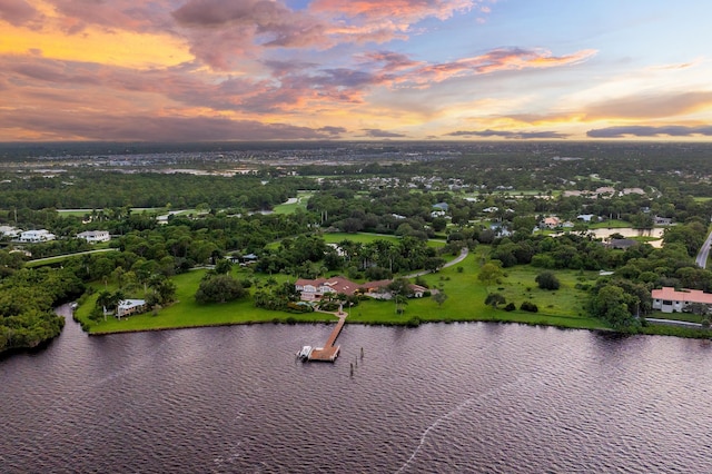 aerial view at dusk featuring a water view