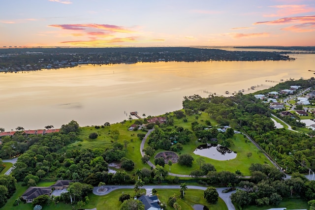 aerial view at dusk featuring a water view