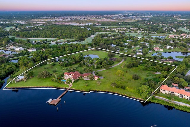 aerial view at dusk featuring a water view