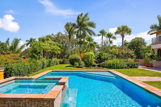 view of pool featuring an in ground hot tub, pool water feature, and a lawn