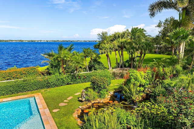 view of swimming pool with a lawn and a water view