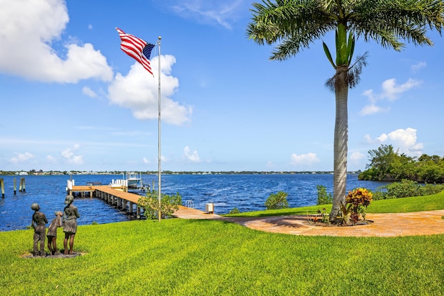 dock area with a yard and a water view