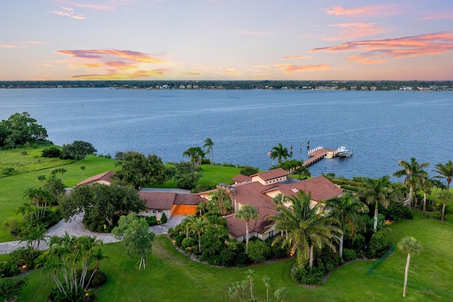 aerial view at dusk featuring a water view