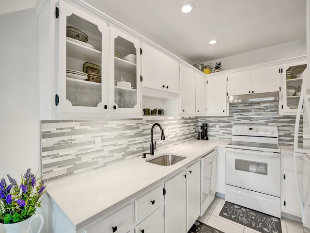 kitchen with white appliances, sink, tasteful backsplash, light tile patterned flooring, and white cabinetry