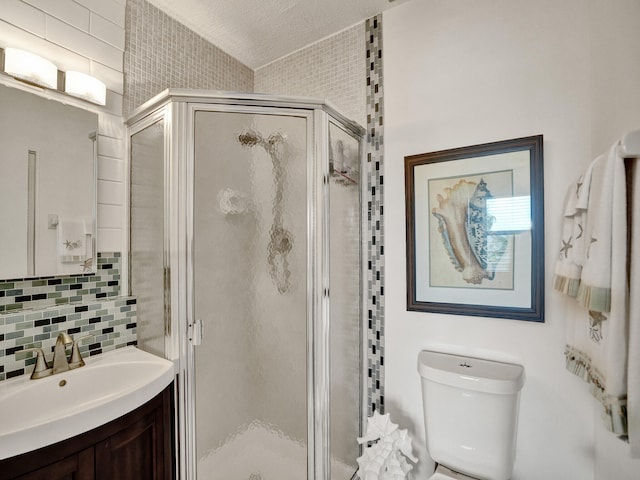 bathroom featuring tasteful backsplash, walk in shower, vanity, a textured ceiling, and toilet