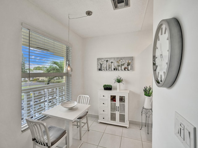 dining space with light tile patterned floors and a textured ceiling