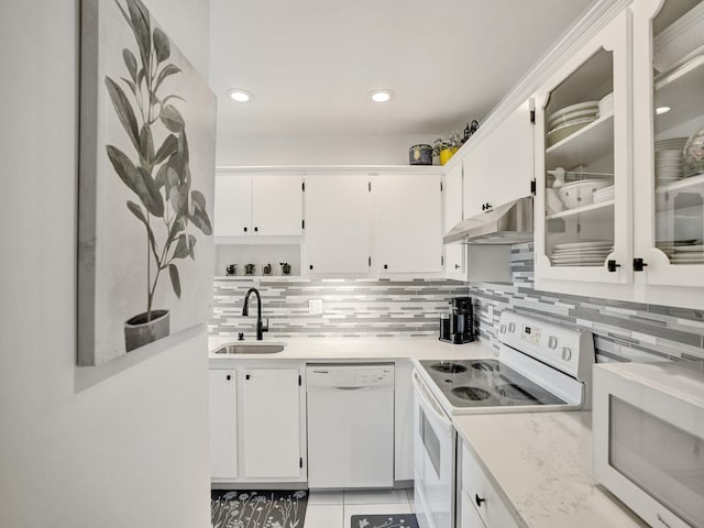 kitchen featuring decorative backsplash, sink, white cabinets, and white appliances