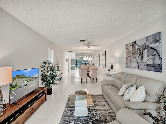 living room featuring ceiling fan, light tile patterned floors, and a textured ceiling