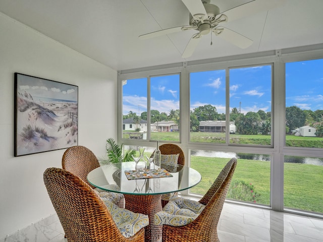 sunroom with a water view, plenty of natural light, and ceiling fan