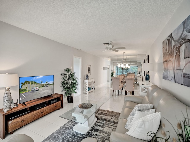 tiled living room featuring ceiling fan with notable chandelier and a textured ceiling