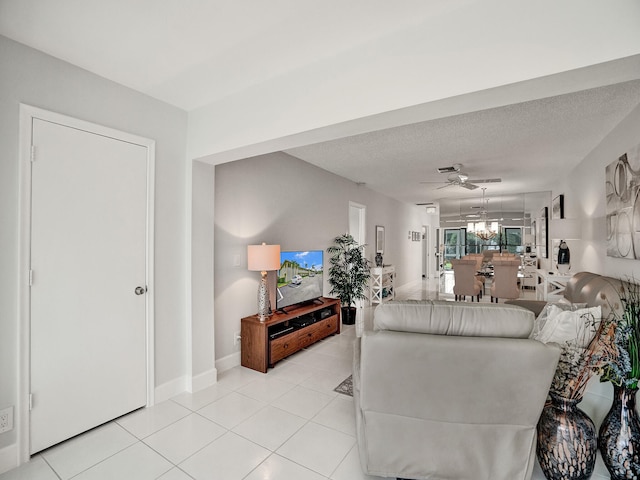 living room with light tile patterned floors, a textured ceiling, and ceiling fan