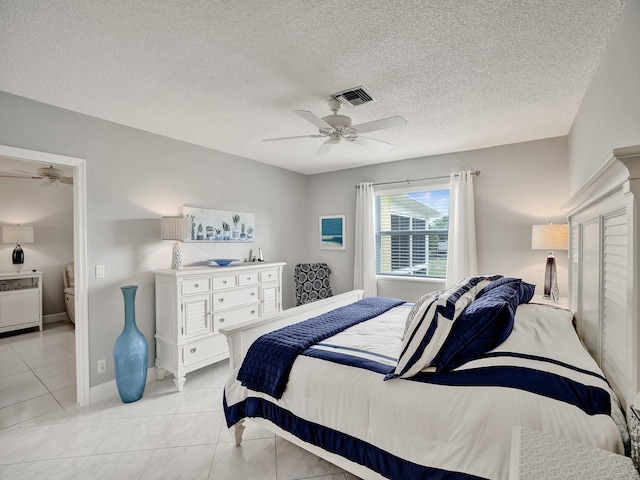 tiled bedroom featuring a textured ceiling and ceiling fan