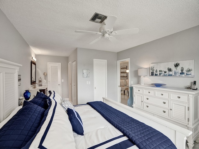 bedroom featuring ceiling fan and a textured ceiling