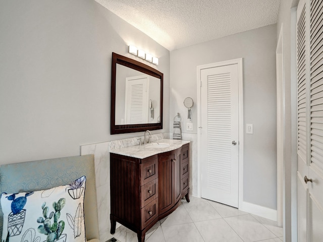 bathroom with tile patterned floors, vanity, and a textured ceiling