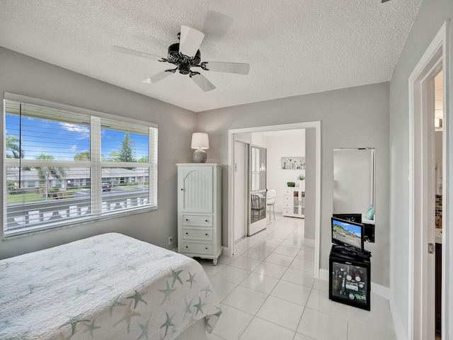 tiled bedroom featuring a textured ceiling, multiple windows, and ceiling fan