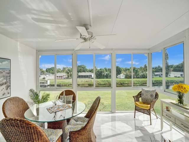 sunroom with a water view and ceiling fan