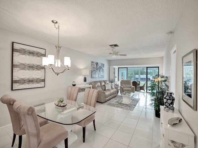 dining room with a textured ceiling, ceiling fan with notable chandelier, and light tile patterned floors